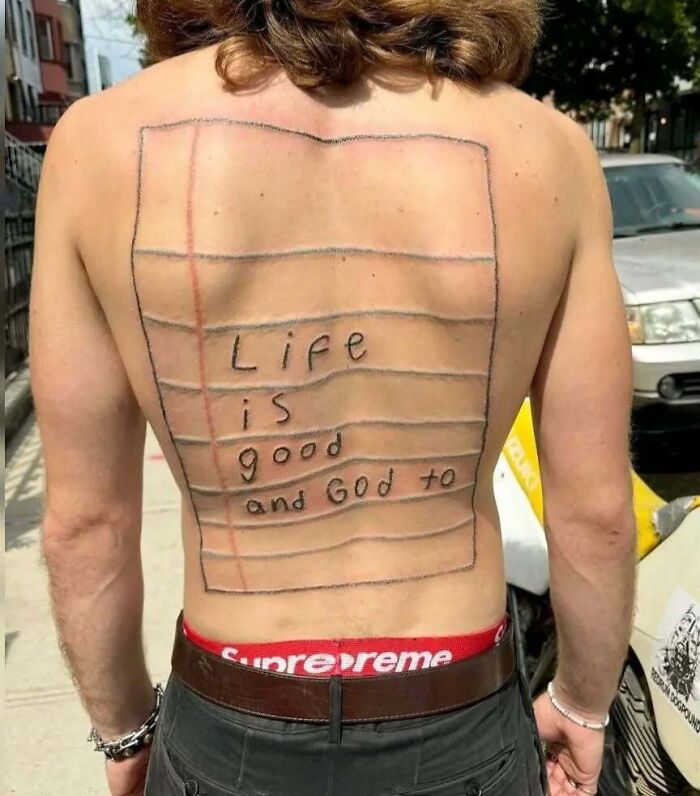 Person with a funny back tattoo of a lined notebook page and handwritten text, showcasing interesting and bad tattoos.