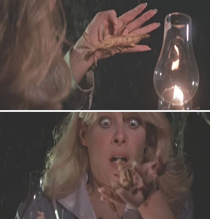 Woman reacting in horror to large bugs crawling on her hand in a behind-the-scenes movie moment with dim lantern light.