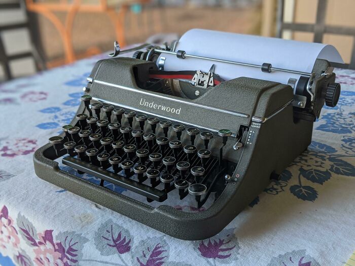 Vintage Underwood typewriter on a floral tablecloth showcasing classic vintage devices in technology history