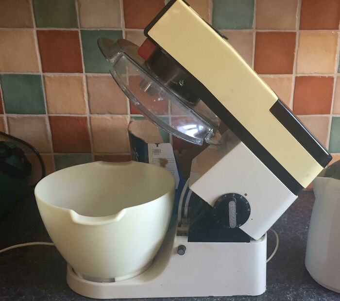 Vintage kitchen mixer with cream-colored bowl and tilting head showcasing vintage devices proving technology progress.