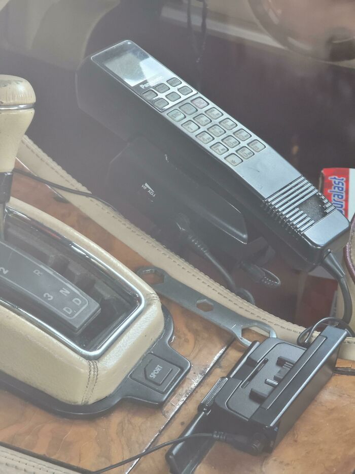 Vintage mobile car phone from the 1980s with wired handset and charger, showcasing vintage devices and technology evolution.