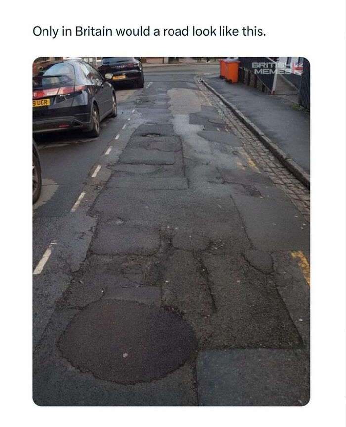 Uneven and patched road in Britain with cars parked along the side, illustrating typical British memes about road conditions.