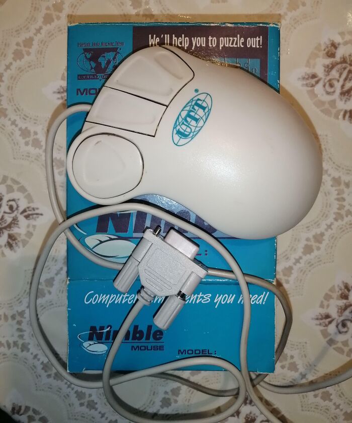 Vintage computer mouse with serial connector on a blue box, showcasing classic technology from vintage devices collection.