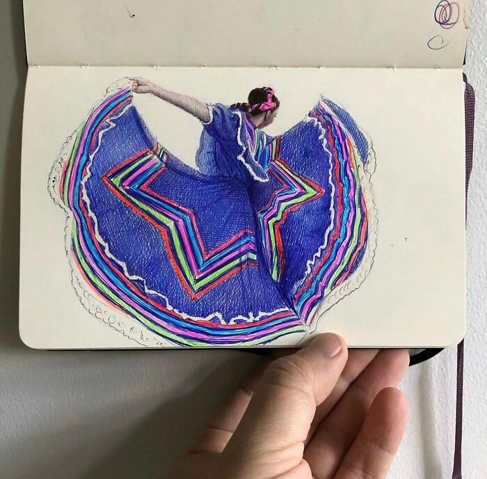Hand holding a tiny sketchbook with a colorful drawing of a dancer, showcasing big emotions in a small artwork.