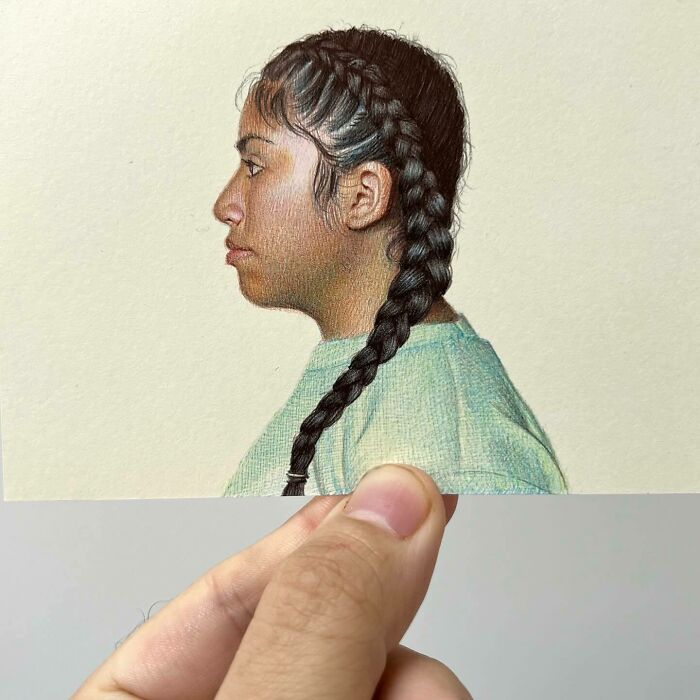 Hand holding a tiny sketchbook showing a detailed portrait, capturing big emotions in everyday moments.