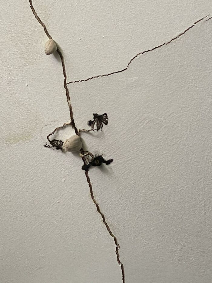 C*****d wall with poorly fixed string and decorative knots, illustrating failed renovation attempts and saving fails.