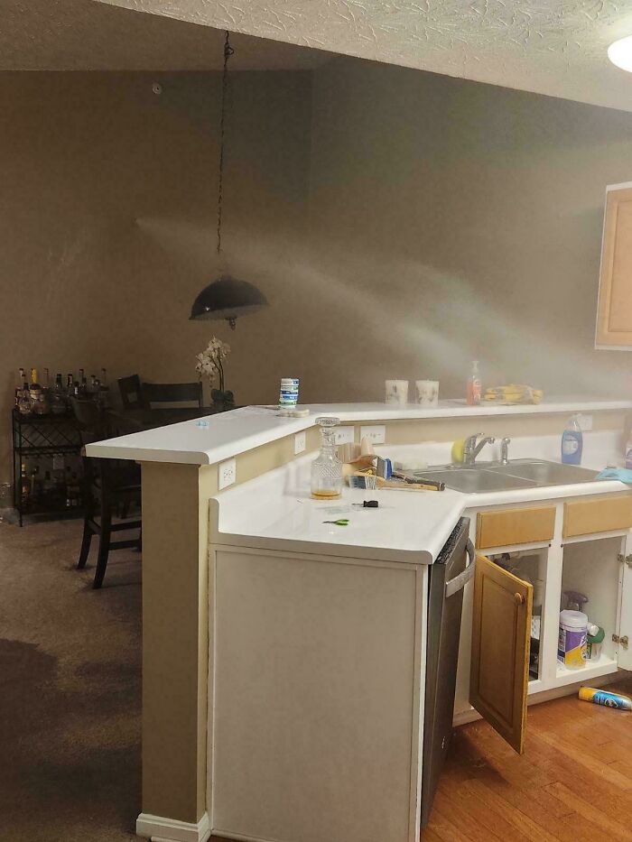 Kitchen renovation fail with mismatched countertop heights and unfinished cabinet doors showing costly renovation mistakes.