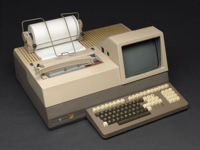 Vintage computing device with integrated monitor, keyboard, and dot matrix printer showcasing vintage devices in technology evolution.