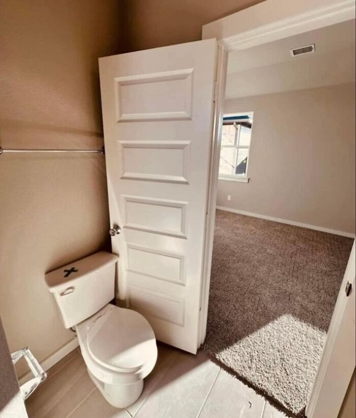 Toilet positioned in a small bathroom with a door that cannot fully open, highlighting renovation errors and saving mistakes.