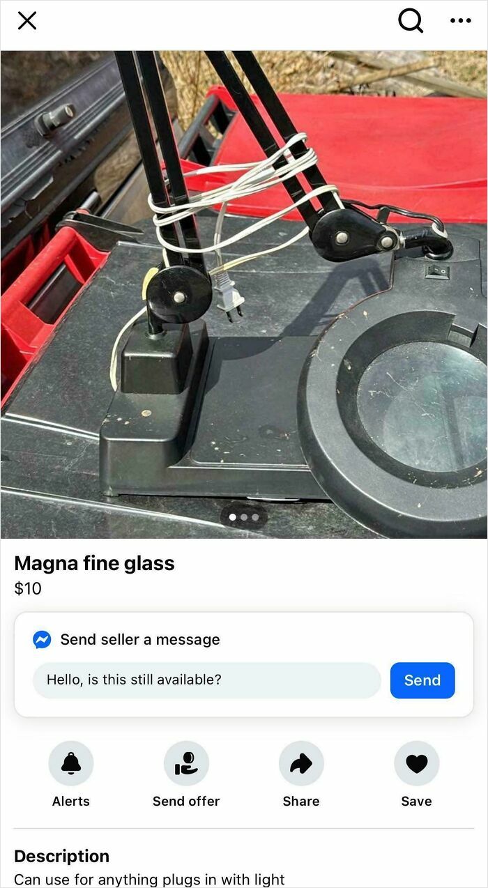 Magnifying glass with adjustable arms and attached power cord on black surface, related to bacteria don’t exist topic.