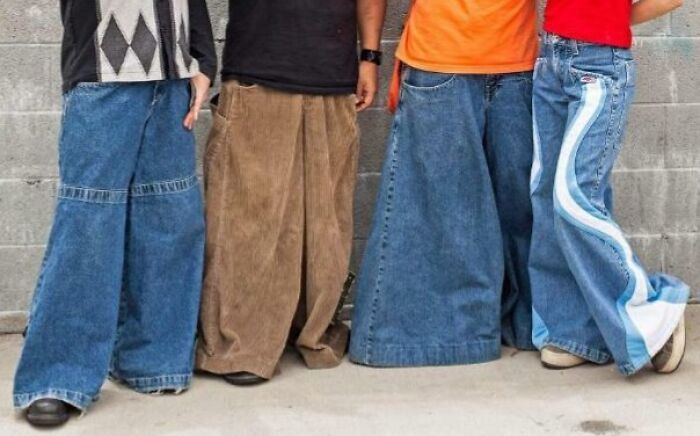 Four people wearing wide leg pants, showcasing cringey nineties fashion trends left behind in denim and corduroy styles.