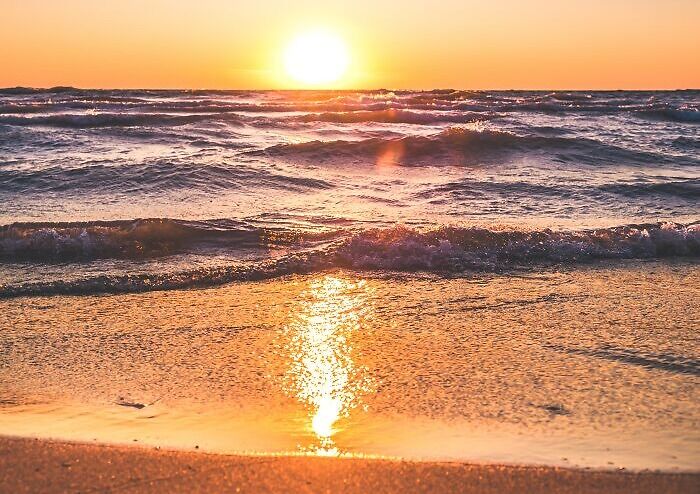 Sunset over the ocean waves reflecting golden light, symbolizing dark family secrets revealed in adulthood.