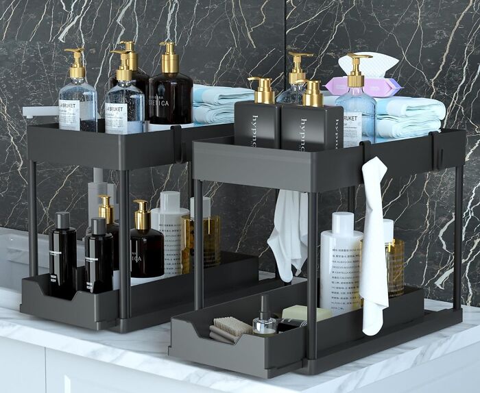 Organized bathroom countertop with black storage trays holding bottles, towels, and toiletries for clutter-free living.