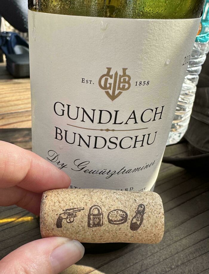 Wine cork with clever symbols held in front of Gundlach Bundschu bottle illustrating overlooked problem-solving.