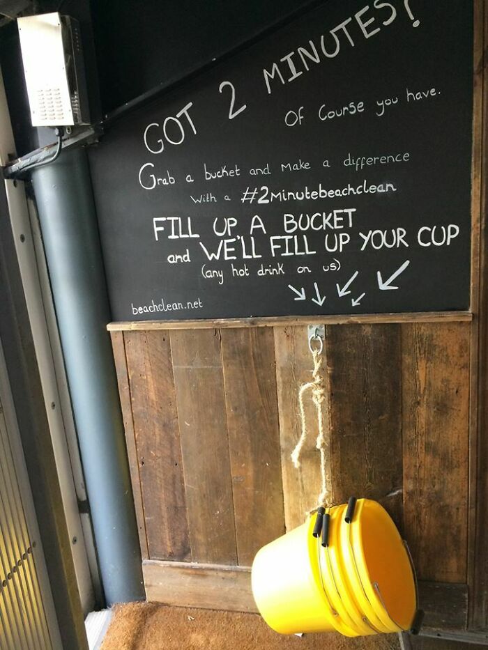 Chalkboard encourages clever bucket use for quick beach clean with incentive of free hot drink, showcasing overlooked problem solution.