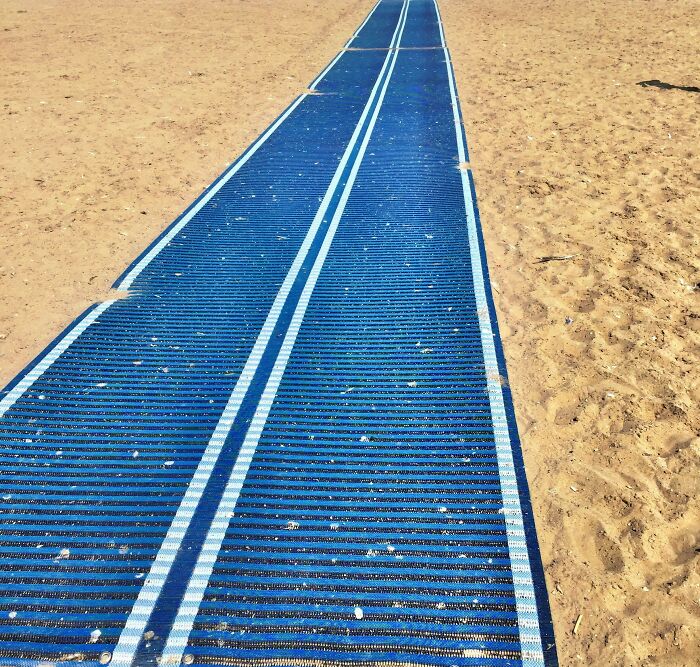 Blue beach mat laid out on sandy ground as a clever solution for easier walking on sand path