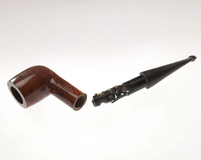 Disassembled spy pipe revealing hidden CIA spy technology components inside the wooden and black parts.