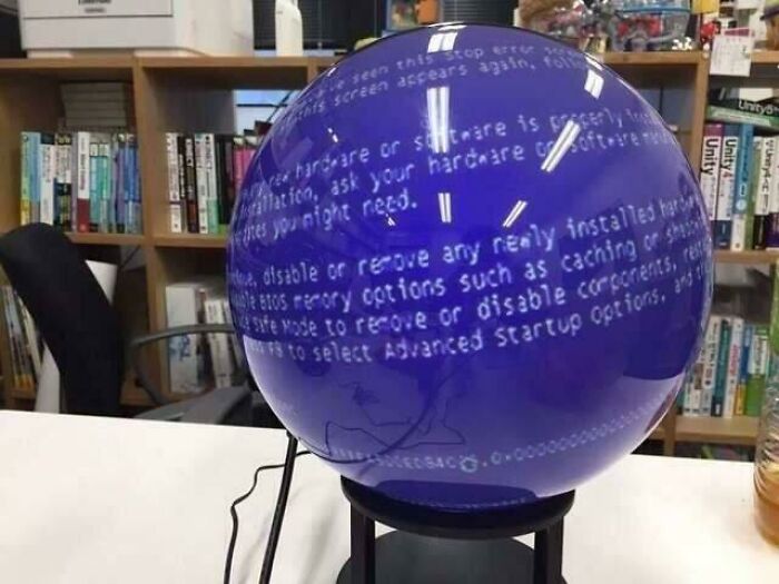 Blue spherical object showing a computer error message reflection, illustrating hilarious tech fails and computer skills humor.