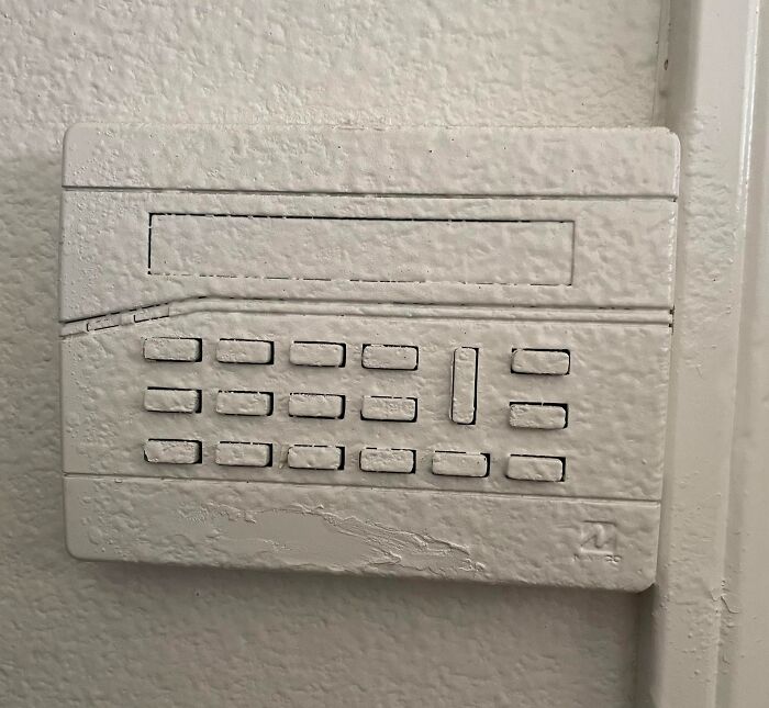 Worn and peeling security keypad painted over, an example of infuriating landlord special frustrating renters.
