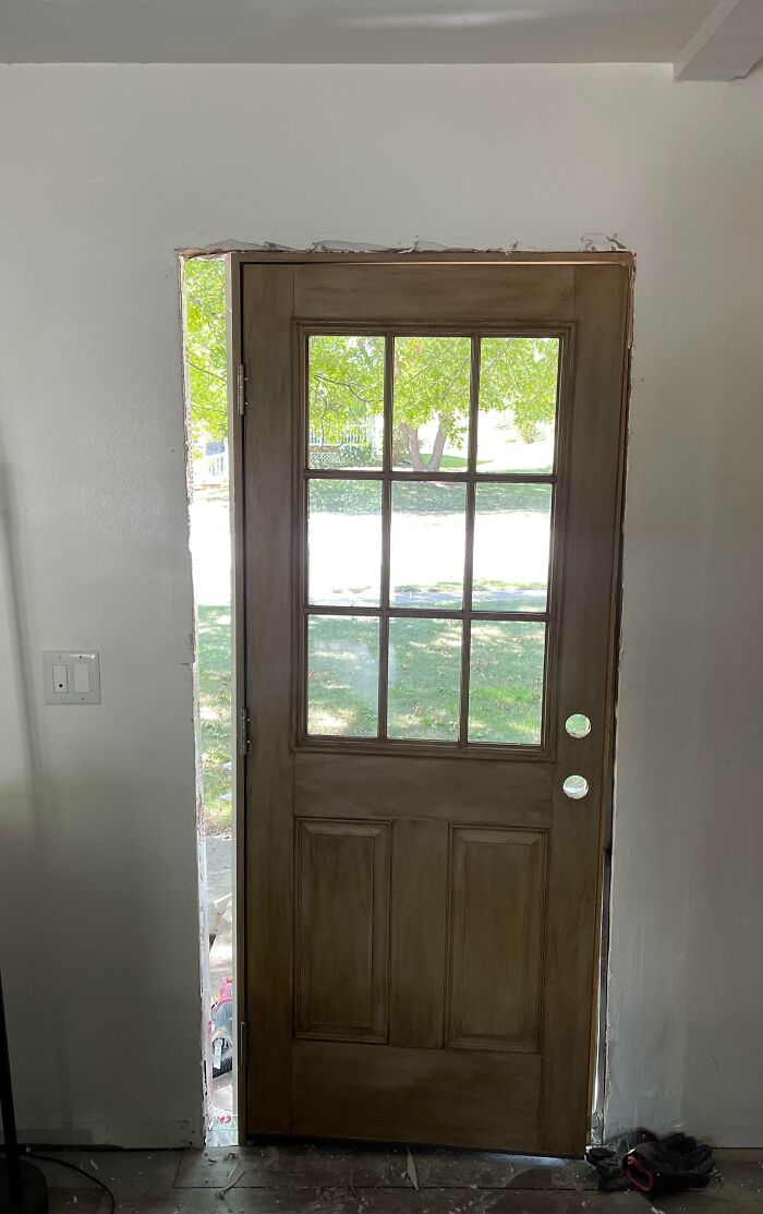 Wooden door poorly installed with large gaps around the frame, an example of infuriating landlords and landlord specials frustrations.
