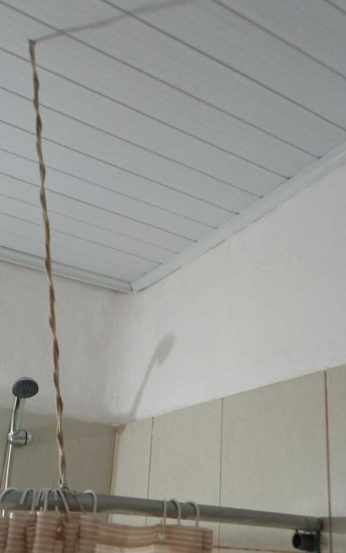 Rope used as a shower curtain hanger inside a bathroom, an example of infuriating landlords and landlord specials.