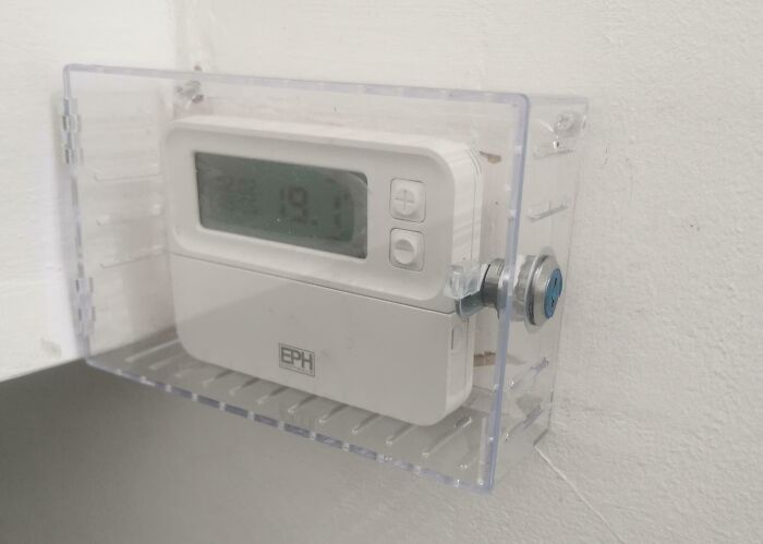 Thermostat locked inside a plastic case, an example of infuriating landlord control in rental properties.