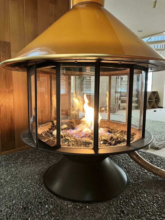 Mid-century designs featuring a vintage style indoor fireplace with glass panels and a conical hood.