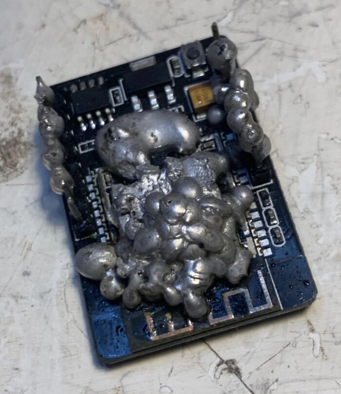 Close-up of an electronic circuit board with melted solder blobs showing one of the hilarious tech fails in hardware assembly.
