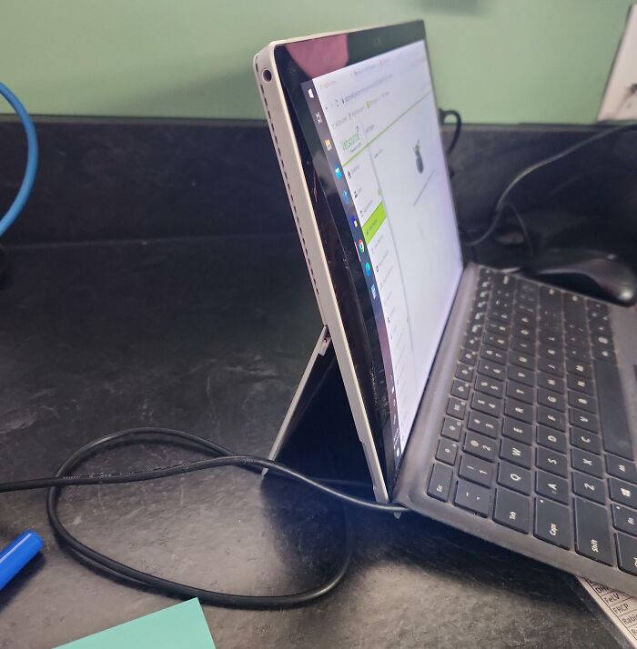 Tablet with broken screen held by a kickstand on desk, showing a tech fail related to computer skills and device damage.