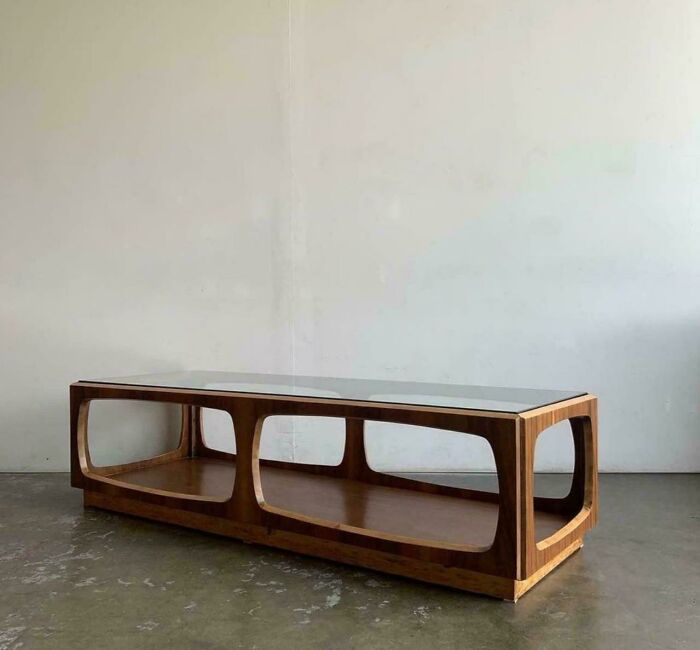 Mid-century design wooden coffee table with open geometric frame and glass top showcasing vintage charm.