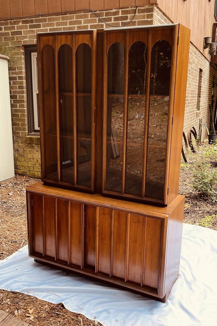 Mid-century vintage wooden cabinet with glass doors showcasing classic mid-century designs and effortless vintage charm.