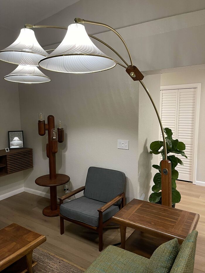 Mid-century designs featuring vintage wooden furniture and a retro arc floor lamp in a cozy living room setting.