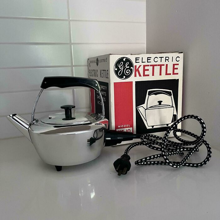 Vintage mid-century electric kettle with original box, featuring sleek chrome design and retro black handle and cord.