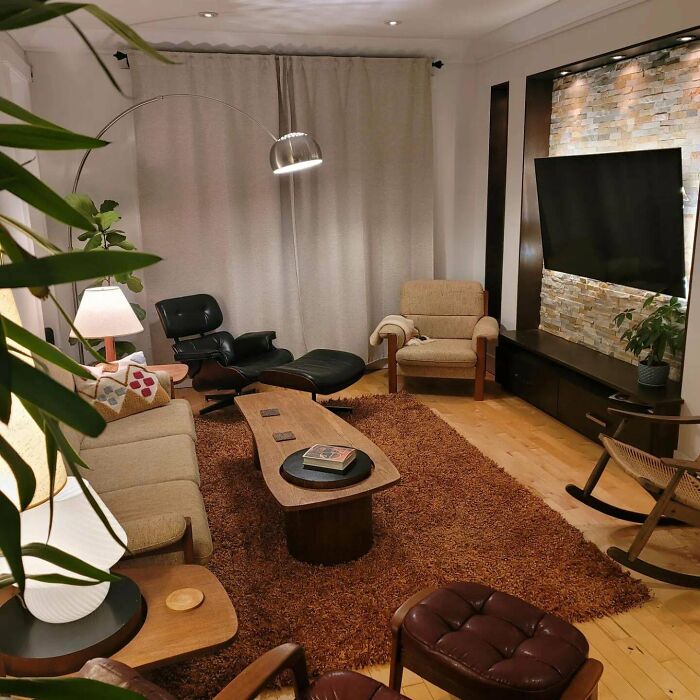 Mid-century living room with vintage charm featuring retro furniture, warm lighting, and textured rug in a cozy setting.