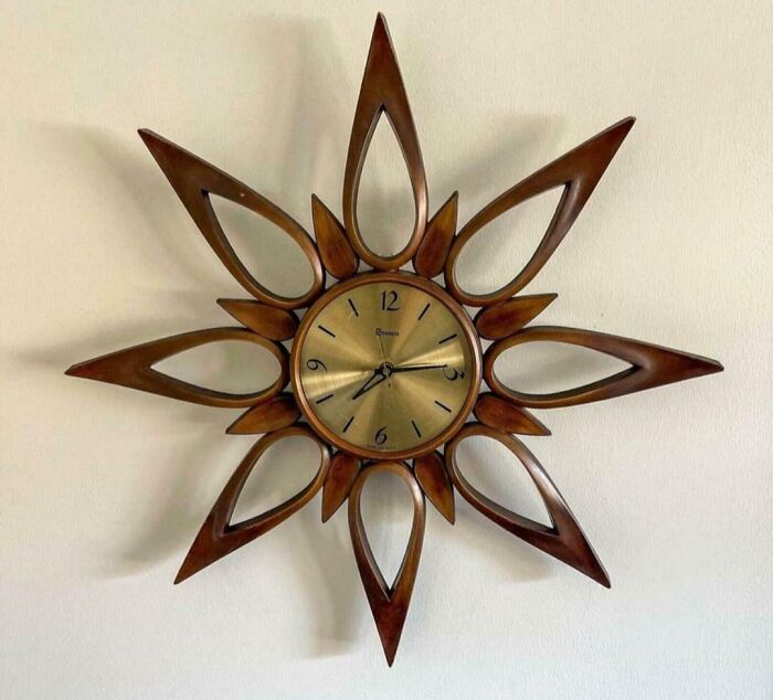 Mid-century wall clock with wooden sunburst design showcasing vintage charm and effortless retro style.