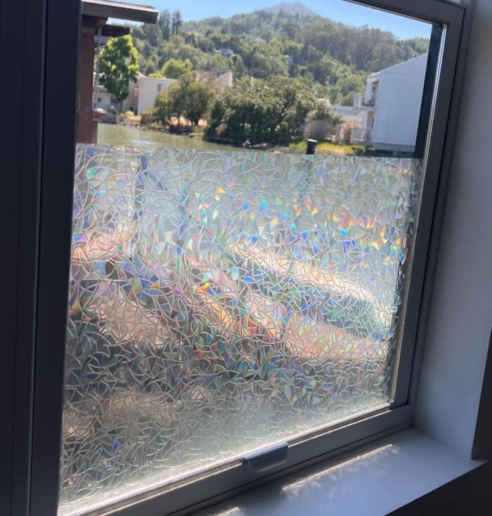 Window with decorative privacy film applied as a quick home upgrade reflecting light with a colorful pattern.
