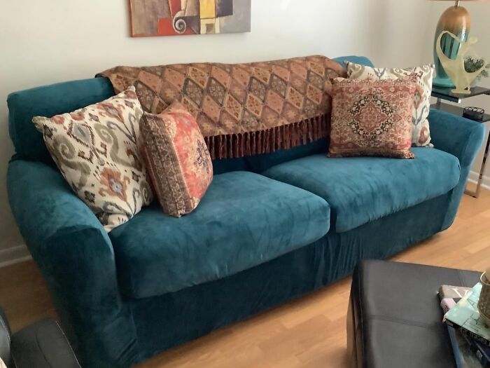 Teal velvet sofa with patterned cushions and a decorative throw, showcasing home upgrades for stylish weekend wins.