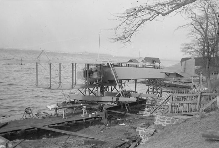 Vintage photo of an early seaplane on a dock illustrating the magic of aviation history by the water.