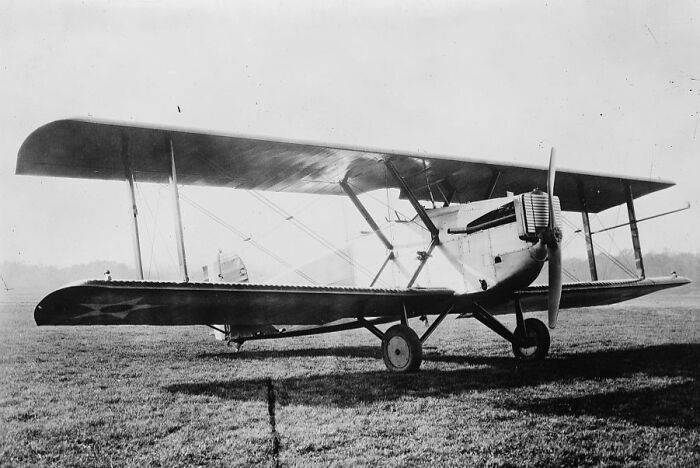 Vintage black and white photo of a biplane aircraft on grass capturing the magic of aviation history.