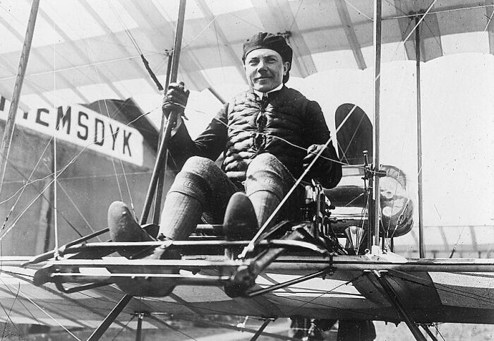 Vintage photo of a pilot seated in an early plane, capturing the magic of aviation history and aircraft design.