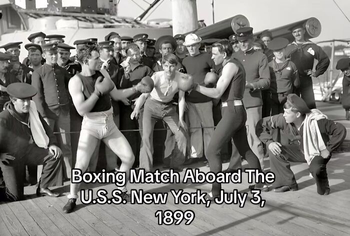 Boxing match aboard U.S.S. New York in 1899 with sailors watching, capturing monumental life moments frozen in time.
