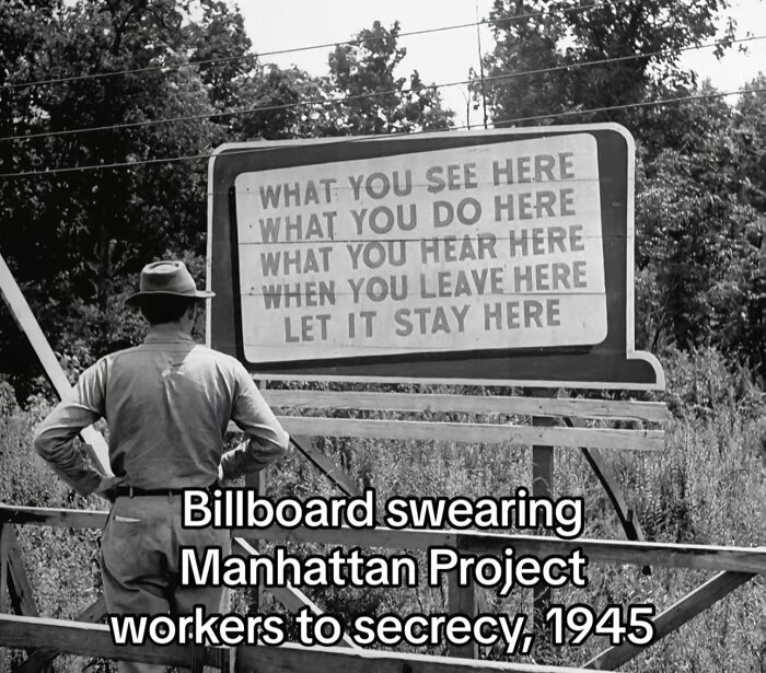 Man standing by 1945 Manhattan Project billboard enforcing secrecy in a monumental life moment frozen in time.