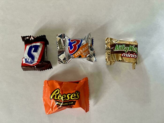 Small candy bars including Snickers, 3 Musketeers, Milky Way, and Reese's, illustrating products getting smaller and more expensive.