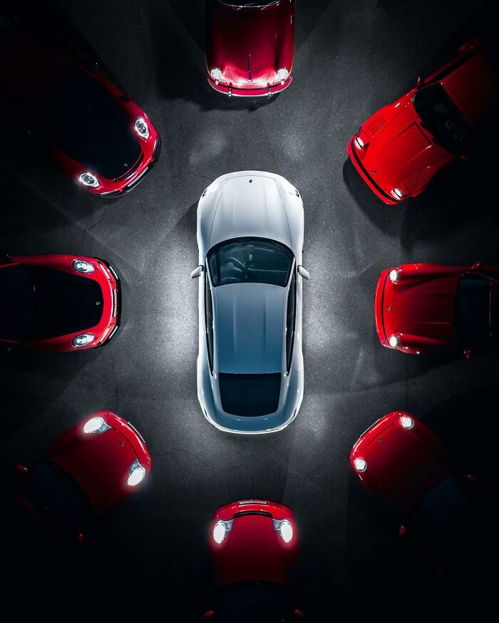 Aerial view of a white car surrounded by multiple red cars, captured in a stunning aerial photo by Borsch.