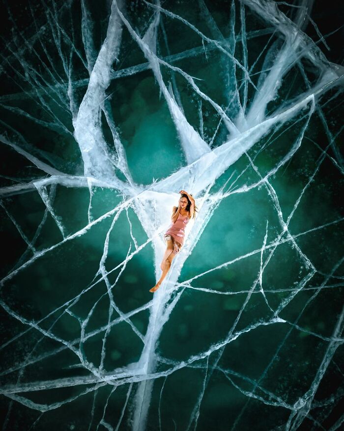 Aerial photo of a woman in a pink dress lying on c*****d ice patterns showcasing stunning aerial photography.