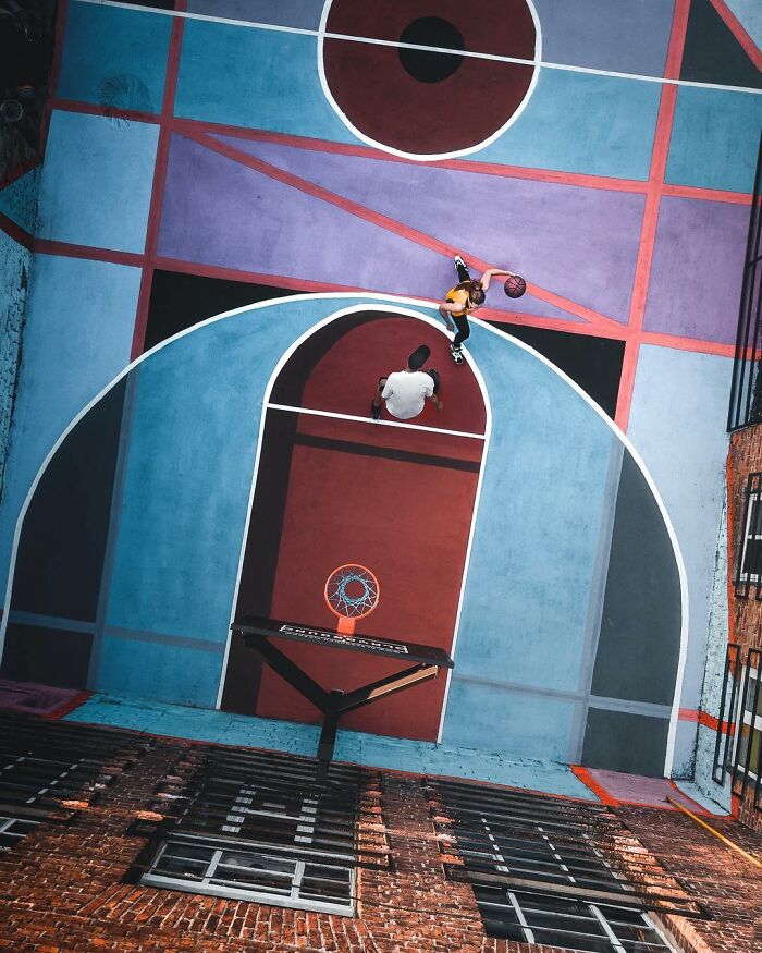 Aerial view of two players on a colorful basketball court with geometric patterns captured in aerial photos.