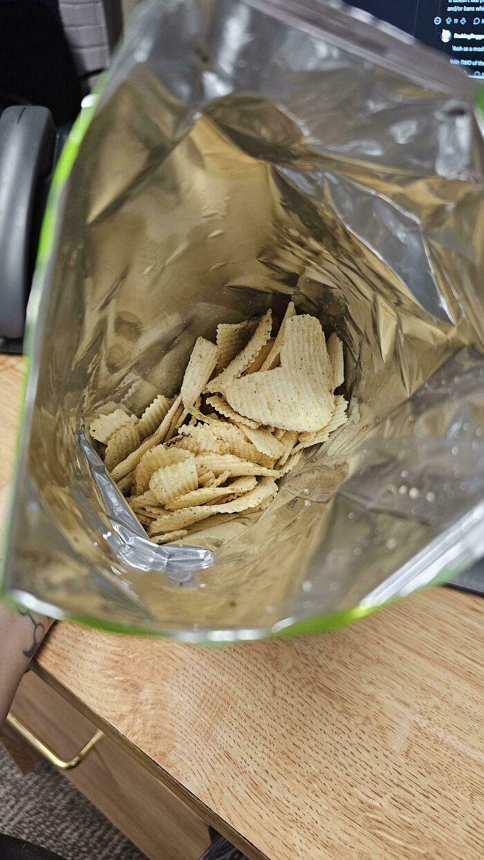 Open chip bag showing noticeably smaller product inside, illustrating how products are getting smaller and more expensive.