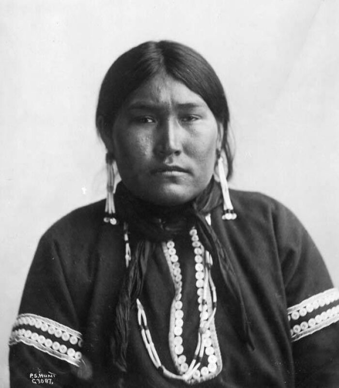 Historic black and white photograph of Native American woman wearing traditional clothing, symbolizing female strength and heritage.