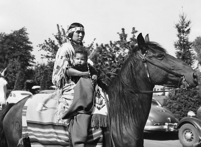 Native American woman and child on horse in time-weathered photograph honoring female strength and heritage.