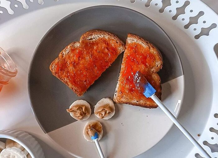 Two slices of toast with orange jam and banana slices topped with peanut butter on a plate, referencing Shark Tank pitches.